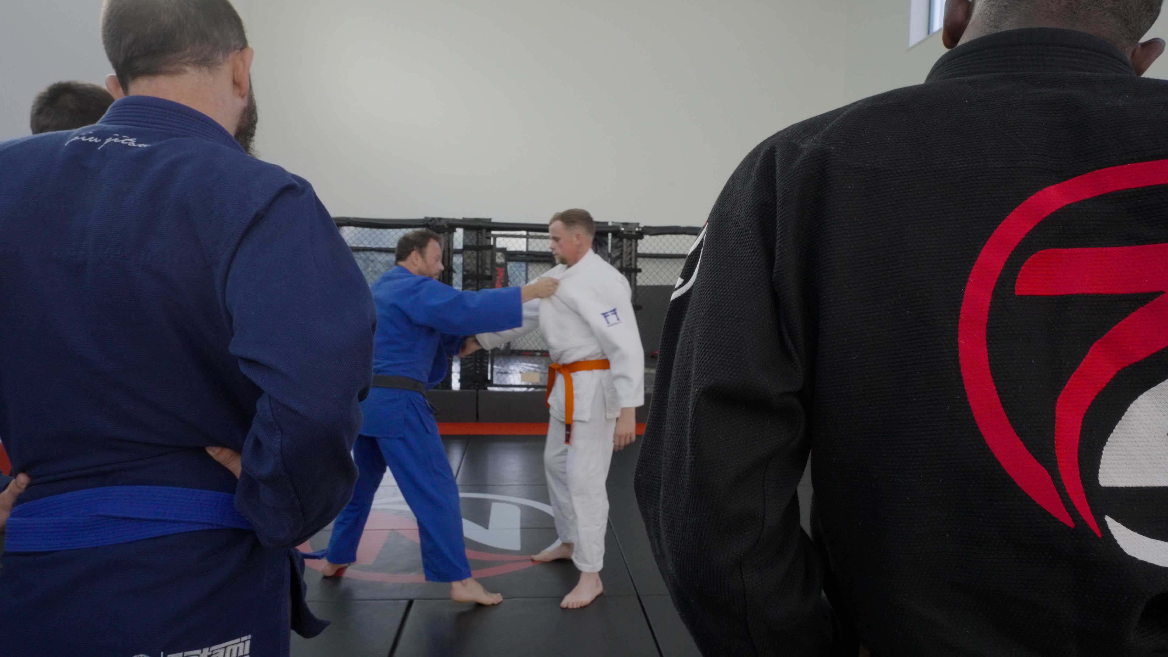 Judo coach demonstrating a gi grip to a class at Zilla Training